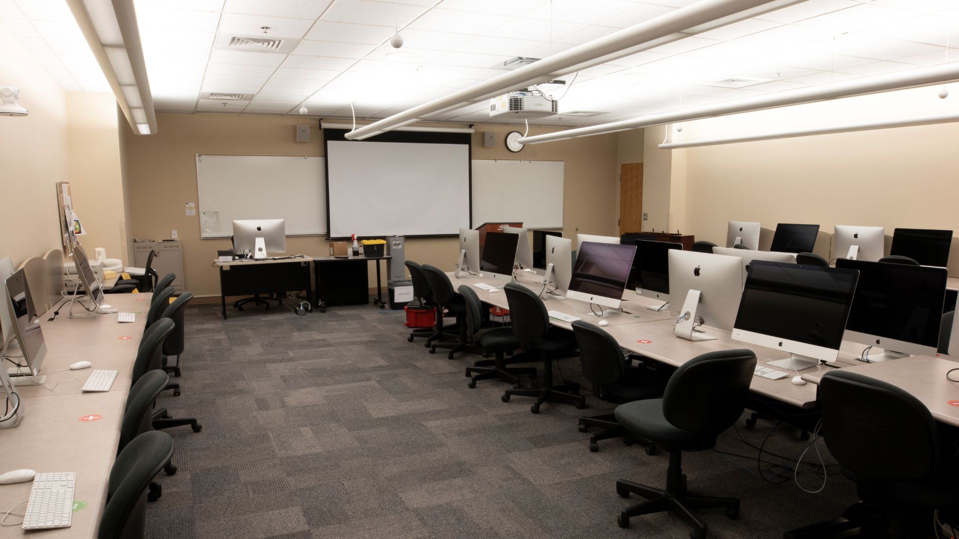 Room with desks, chairs, and Mac workstations
