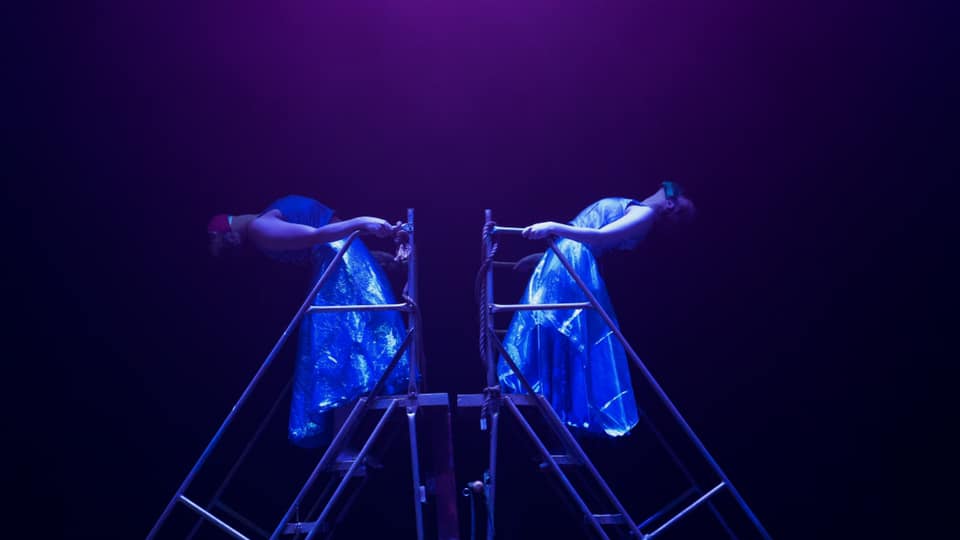 dancers in mood lighting on moving stairs