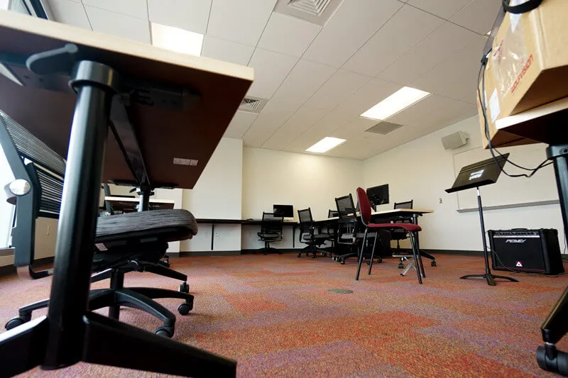 empty classroom with desks, music stands, chairs