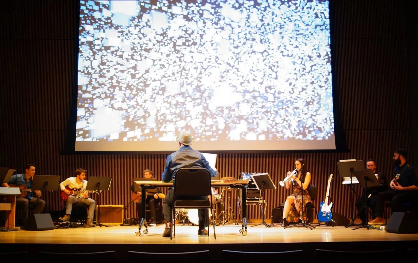 musicians on stage with a video backdrop