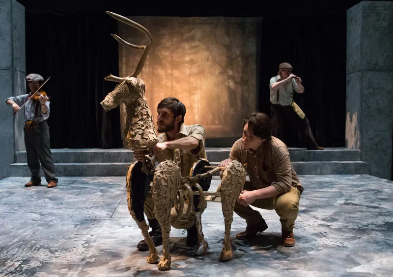 actors on stage with animal-shaped structure